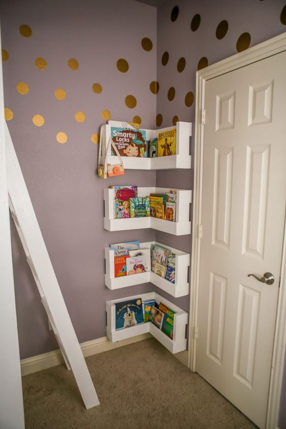 Polka dot wallpaper and behind the door wall shelves with books.